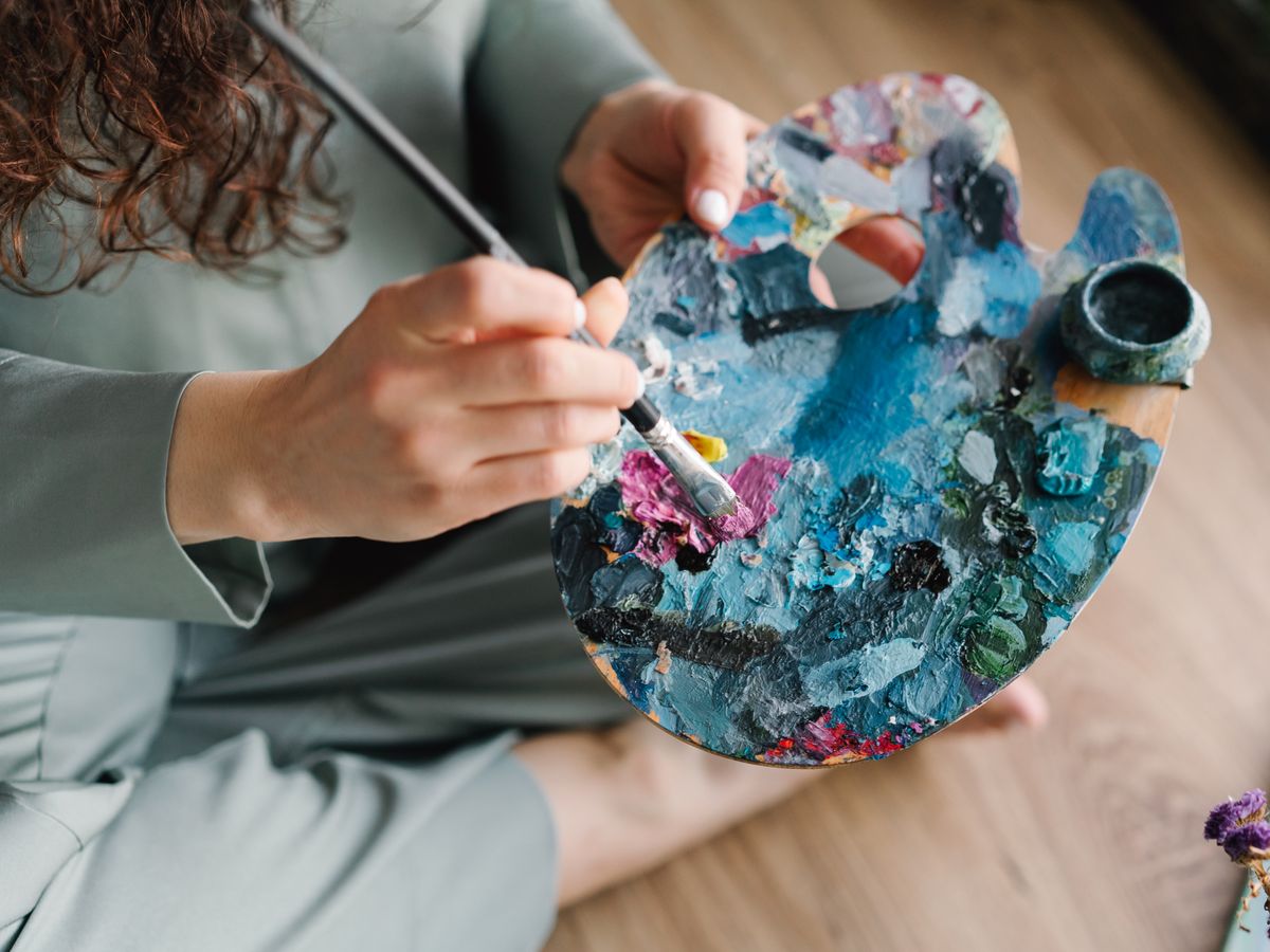 A person painting at an easel